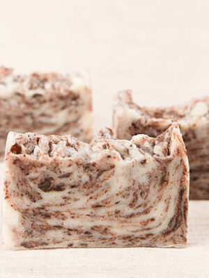 Bars of natural handmade chocolate soap on a linen fabric.