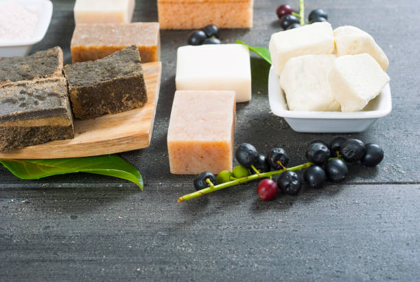 Soaps, henna blocks, raw shea butter on black wood table