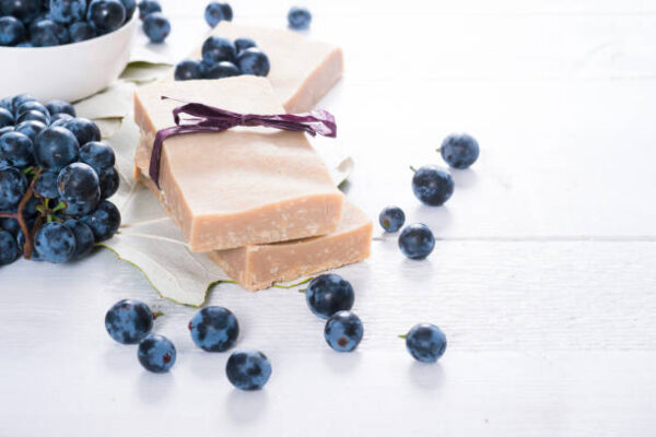 Handmade soaps from red grapes seed oil, on white wood table
